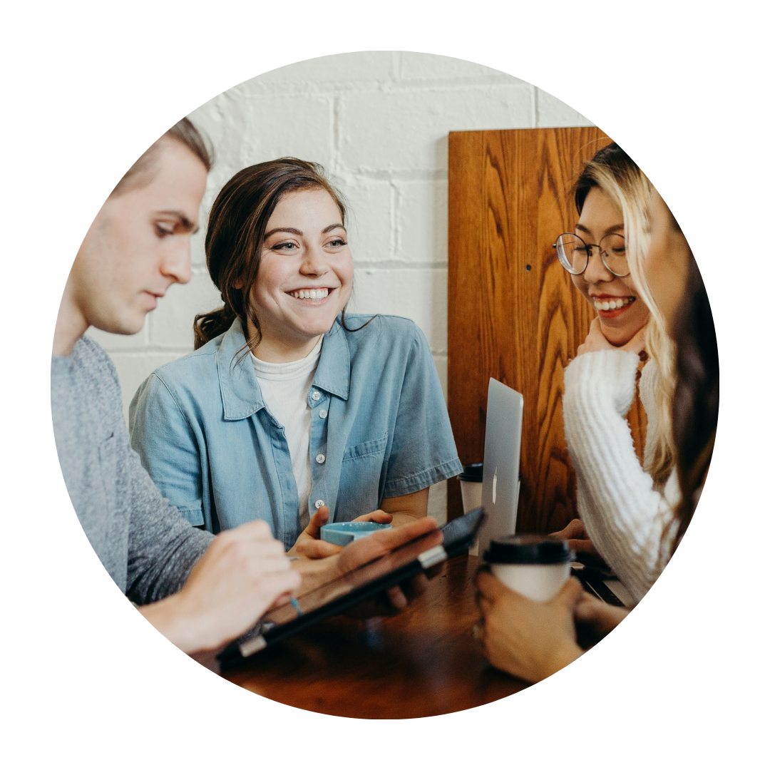 Women and man smiling looking at computer and paper